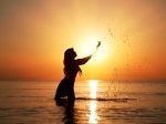 13125722-silhouette-of-woman-making-splashes-in-the-rays-of-the-rising-sun-horizontal-photo